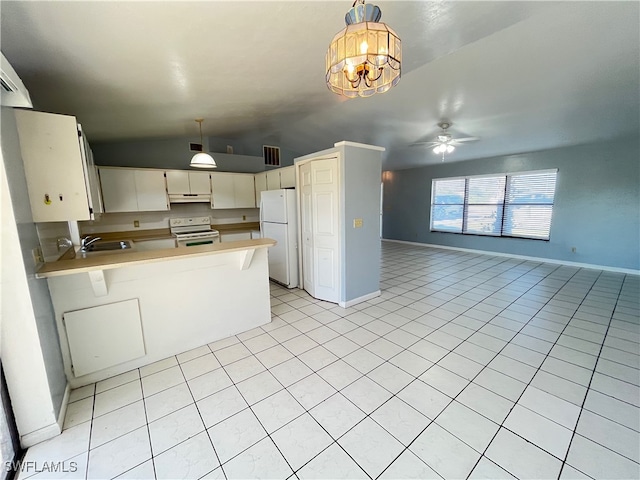 kitchen with pendant lighting, lofted ceiling, white appliances, and kitchen peninsula