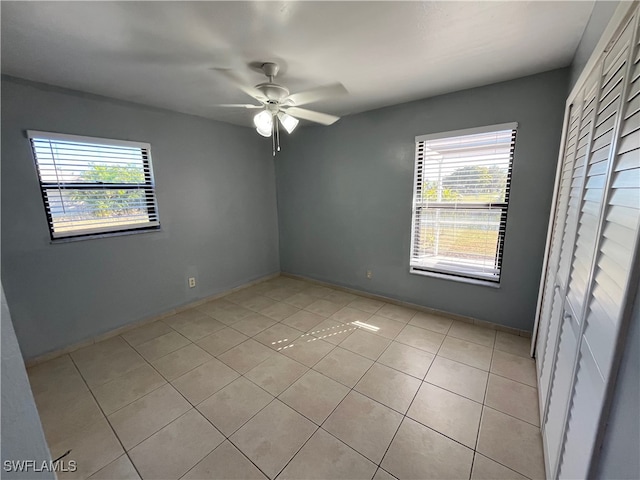 unfurnished bedroom featuring multiple windows, ceiling fan, and light tile patterned flooring