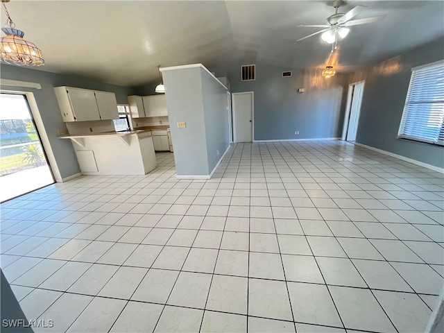 unfurnished living room featuring ceiling fan, light tile patterned flooring, and vaulted ceiling