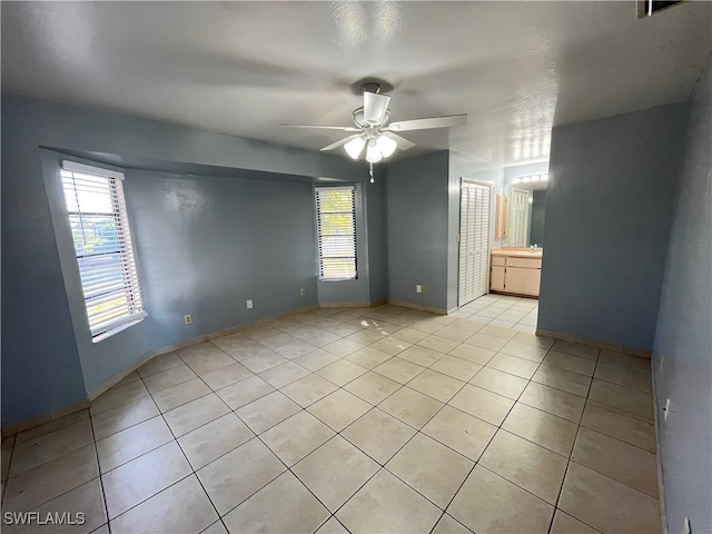 spare room featuring ceiling fan and light tile patterned floors