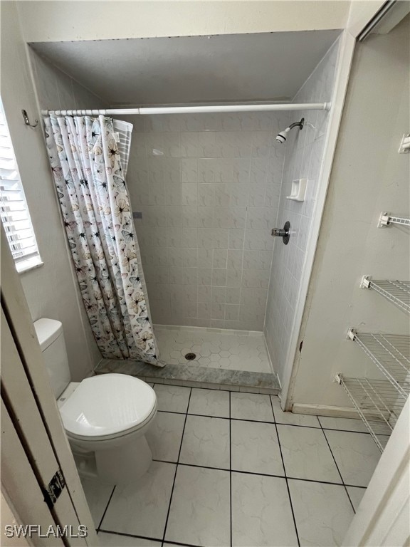 bathroom with tile patterned flooring, curtained shower, and toilet