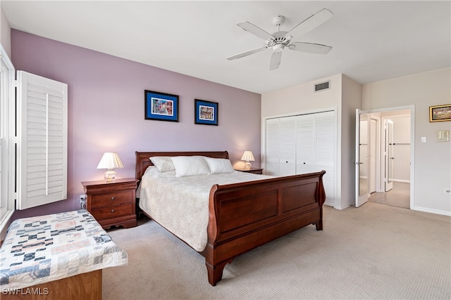 bedroom with ceiling fan, light carpet, and a closet