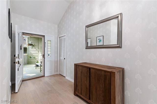 doorway featuring light hardwood / wood-style floors and lofted ceiling