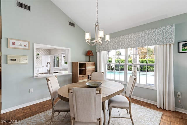 dining room featuring a chandelier, light parquet flooring, high vaulted ceiling, and sink