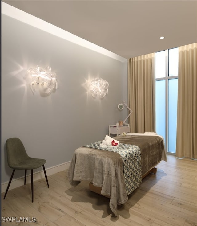 bedroom with light hardwood / wood-style flooring and a wall of windows