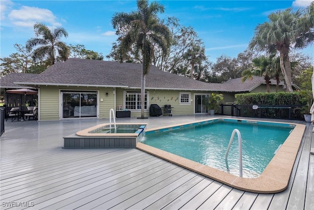 view of pool featuring area for grilling, a deck, and an in ground hot tub