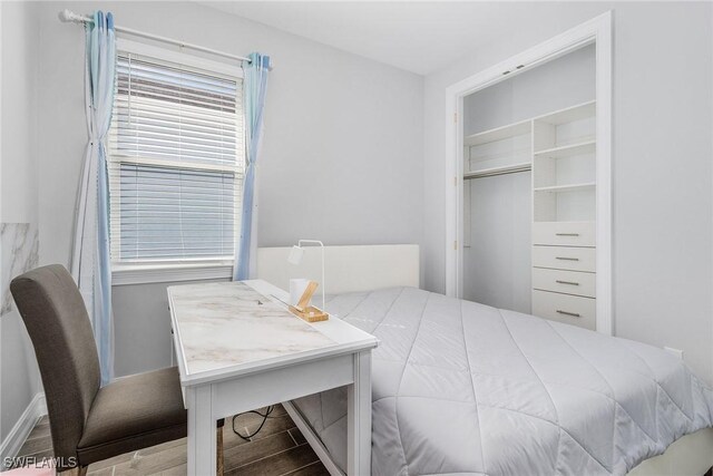 bedroom with multiple windows and hardwood / wood-style flooring