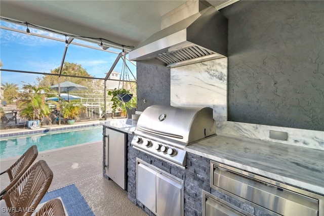 view of patio featuring a lanai, grilling area, and exterior kitchen