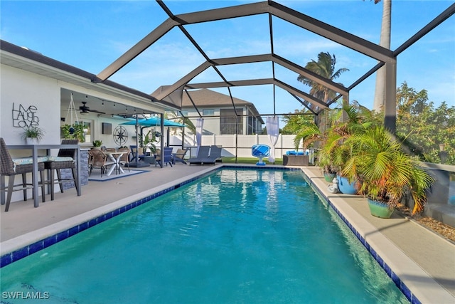 view of pool with ceiling fan, a patio, and a lanai