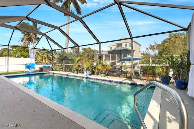 view of swimming pool featuring a patio area and a lanai