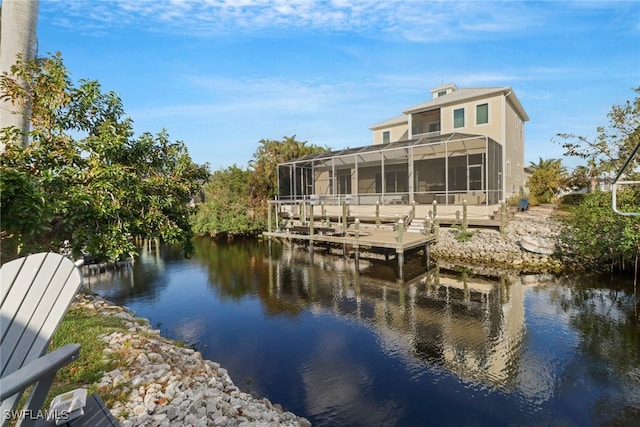 back of house featuring a lanai, a sunroom, and a water view