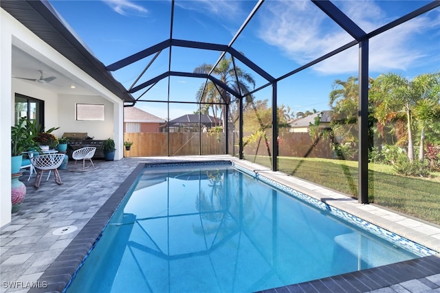 view of swimming pool featuring a lawn, ceiling fan, a lanai, an outdoor living space, and a patio