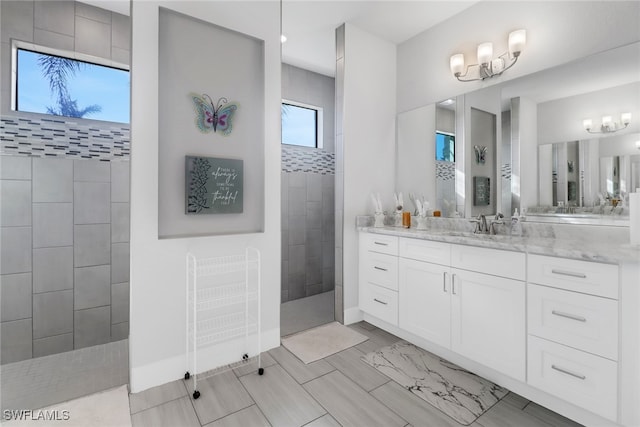 bathroom with tiled shower and vanity