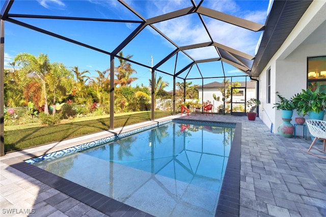 view of swimming pool featuring a lawn, glass enclosure, and a patio