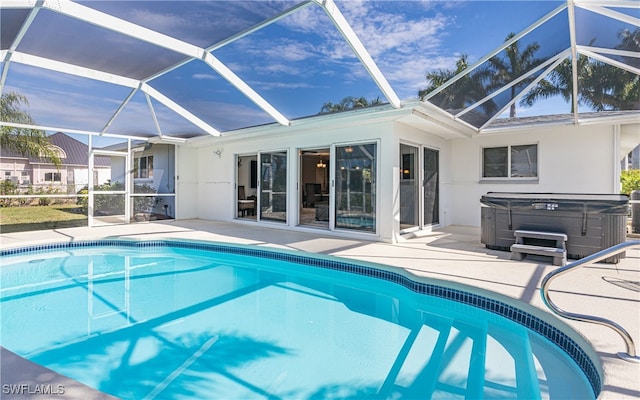 view of pool with a hot tub, a lanai, and a patio area