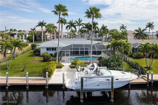 dock area with a yard, a water view, and a lanai