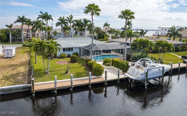 dock area featuring a yard, a water view, and glass enclosure