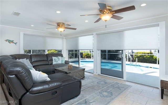 tiled living room with crown molding, a healthy amount of sunlight, and ceiling fan