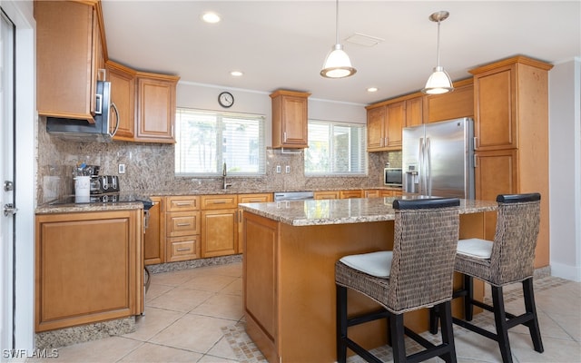 kitchen featuring backsplash, stainless steel appliances, a kitchen bar, and a kitchen island