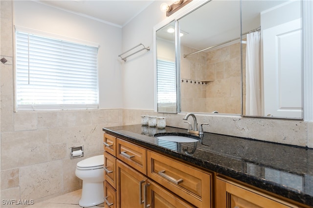 bathroom with toilet, vanity, tile walls, and a wealth of natural light