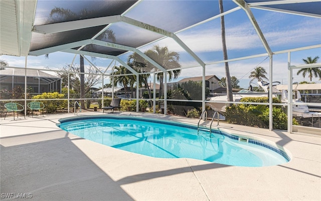 view of pool with a patio area and glass enclosure