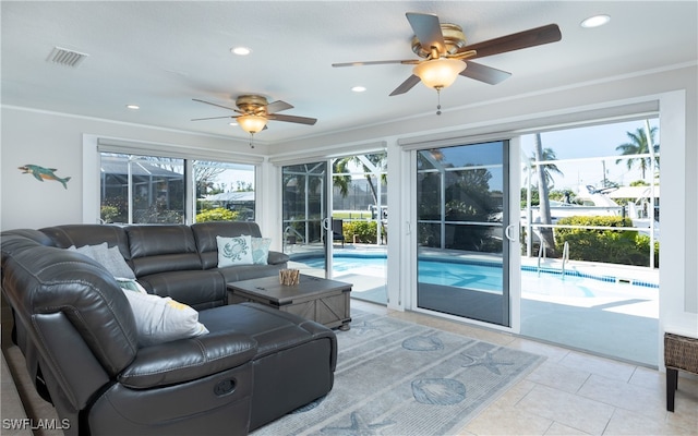 living room featuring ceiling fan, crown molding, and light tile patterned floors