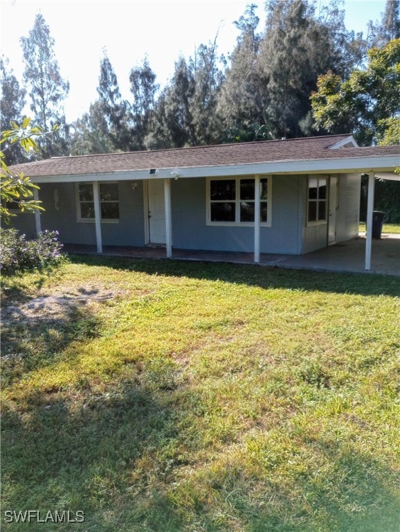 ranch-style house featuring a front lawn and a patio area