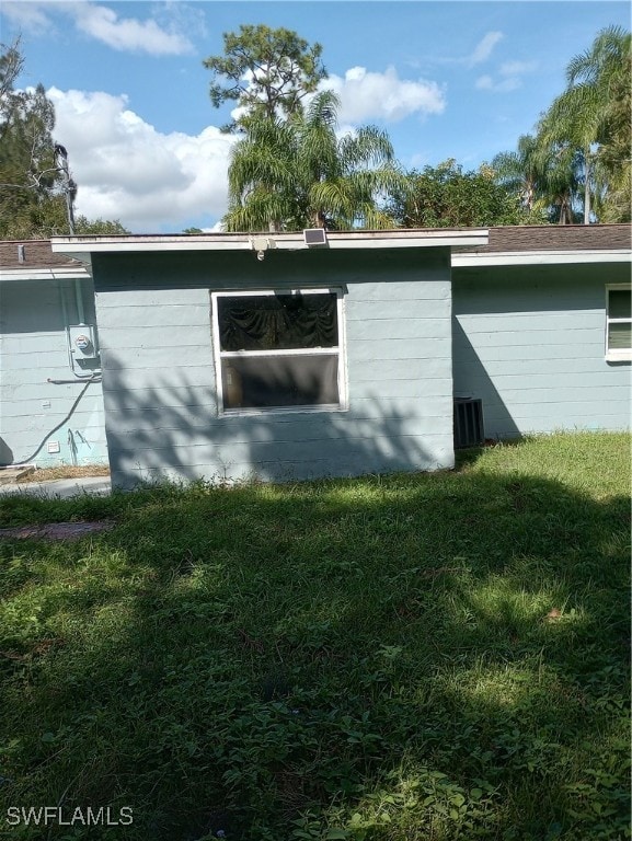 view of side of home with a yard