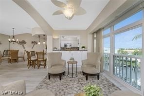 living room with ceiling fan with notable chandelier