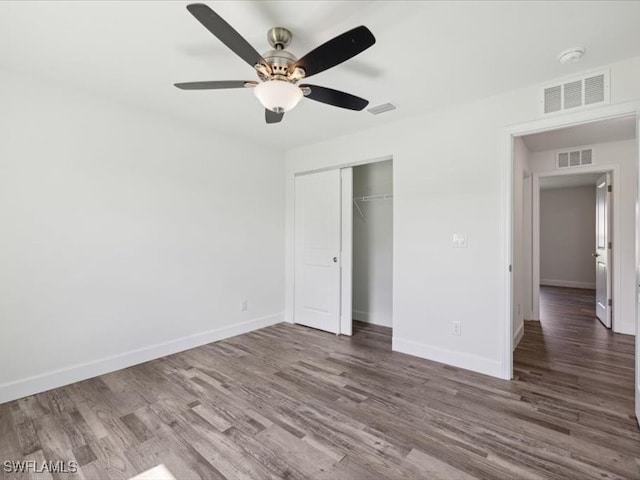 unfurnished bedroom featuring dark wood-type flooring, a closet, and ceiling fan