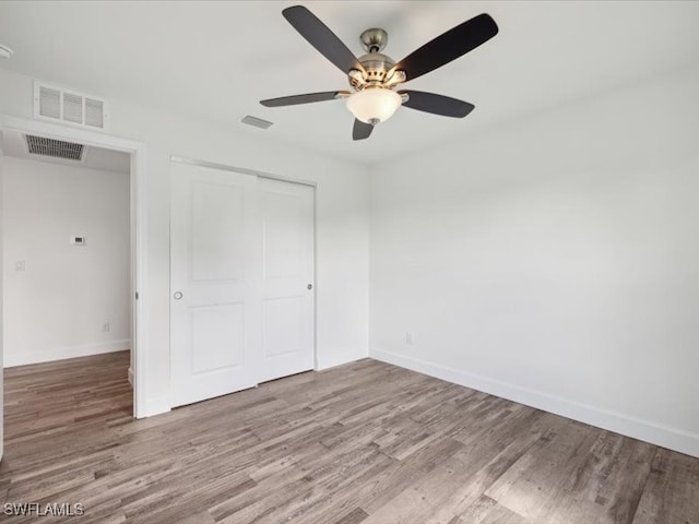 unfurnished bedroom with a closet, light wood-type flooring, and ceiling fan