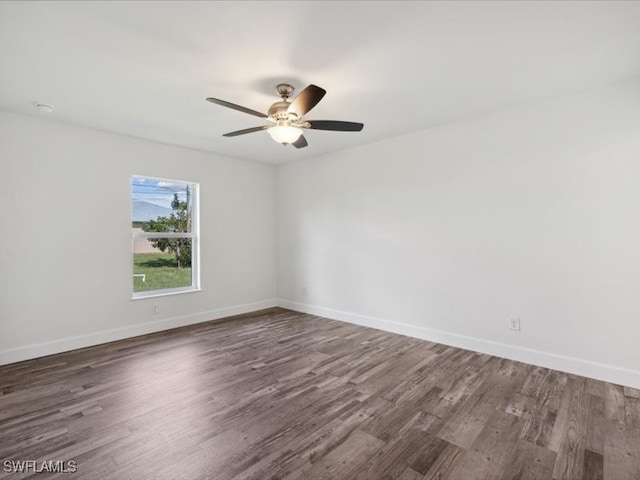 spare room featuring dark wood-type flooring and ceiling fan