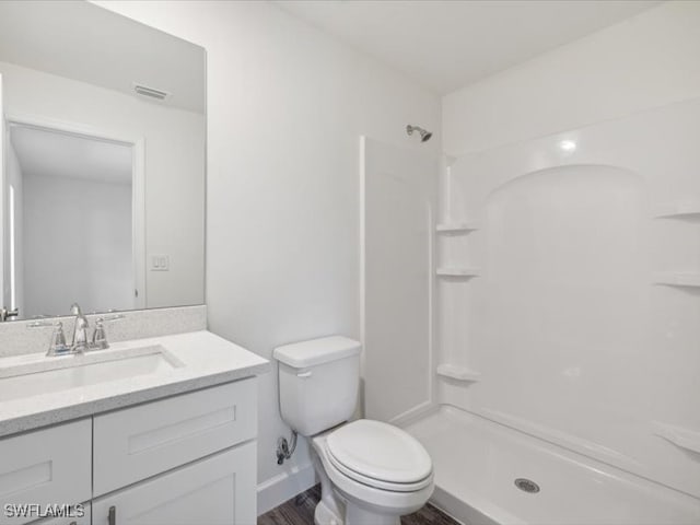 bathroom featuring vanity, toilet, hardwood / wood-style flooring, and a shower