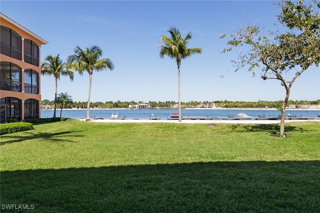 exterior space with a water view and a lawn