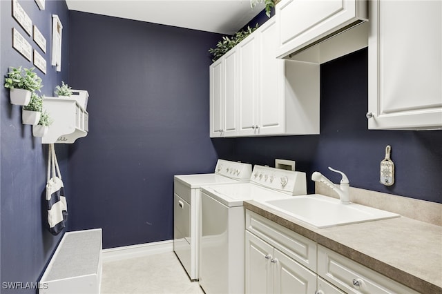 laundry room with cabinet space, light tile patterned flooring, a sink, washer and dryer, and baseboards