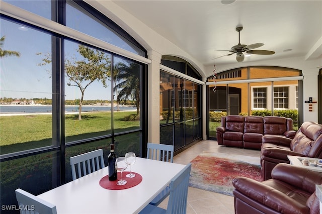 sunroom / solarium featuring a water view, ceiling fan, and vaulted ceiling