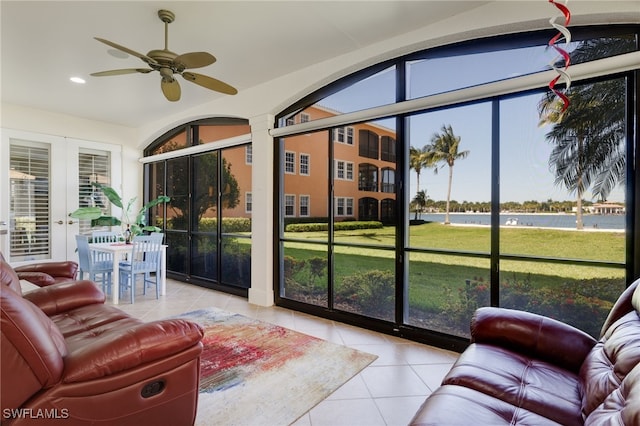 sunroom with a water view and a ceiling fan