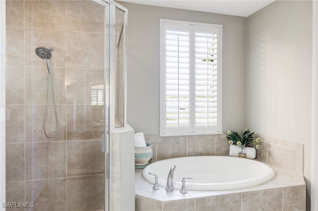 bathroom featuring a garden tub and a shower stall