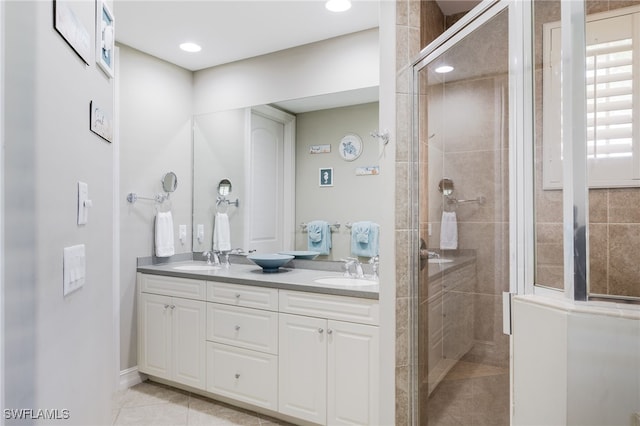 bathroom with vanity, a tile shower, and tile patterned floors