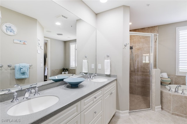 full bathroom featuring a garden tub, a stall shower, a sink, and visible vents