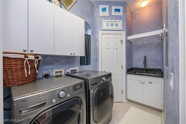 laundry room with cabinets, washer and clothes dryer, sink, and light tile patterned flooring