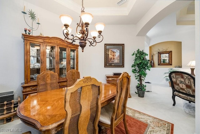 dining space featuring a raised ceiling, a notable chandelier, and ornamental molding