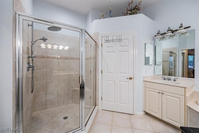 bathroom with a shower with door, tile patterned floors, and vanity