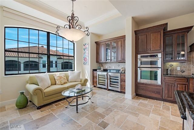 interior space featuring wine cooler, tasteful backsplash, and hanging light fixtures