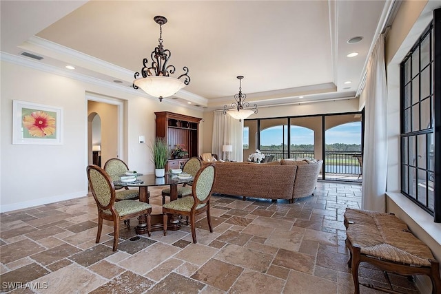 2546 Marquesa Royale Ln Unit 7-302, Naples, FL 34109 - dining space featuring a raised ceiling, ornamental molding, arched walkways, stone tile flooring, and baseboards