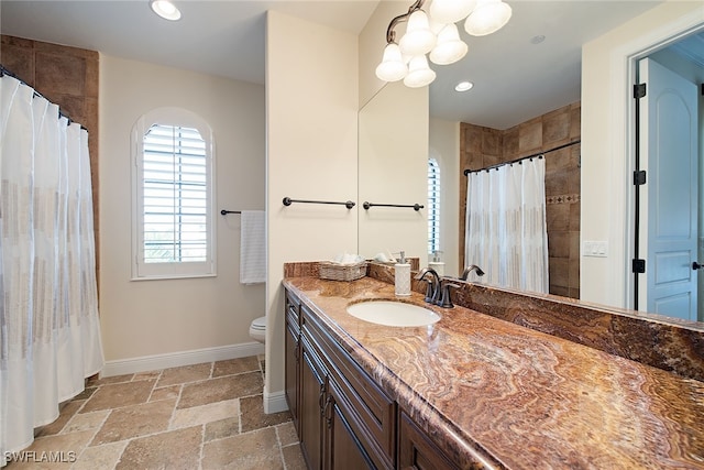 bathroom featuring toilet, curtained shower, and vanity