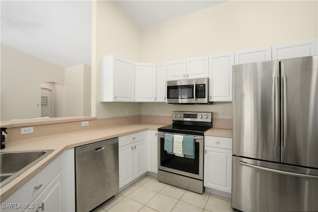 kitchen with white cabinetry, appliances with stainless steel finishes, light tile patterned floors, and kitchen peninsula