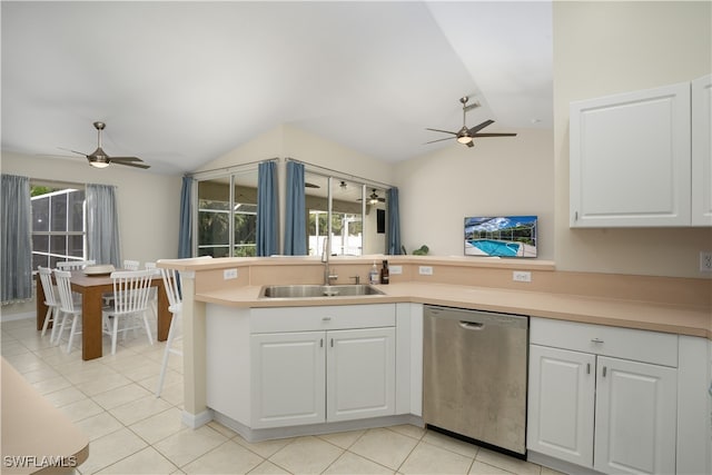 kitchen with kitchen peninsula, white cabinets, vaulted ceiling, dishwasher, and sink