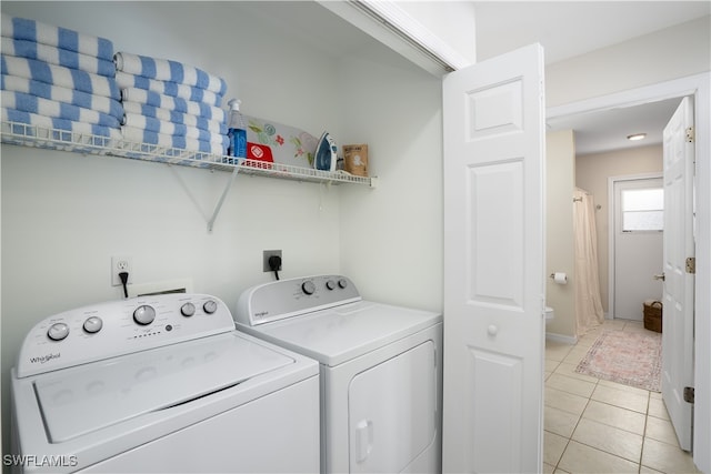 laundry area with separate washer and dryer and light tile patterned floors