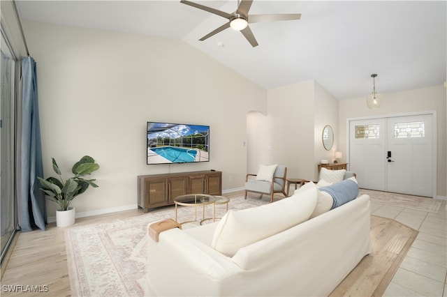 living room with ceiling fan, light wood-type flooring, and vaulted ceiling